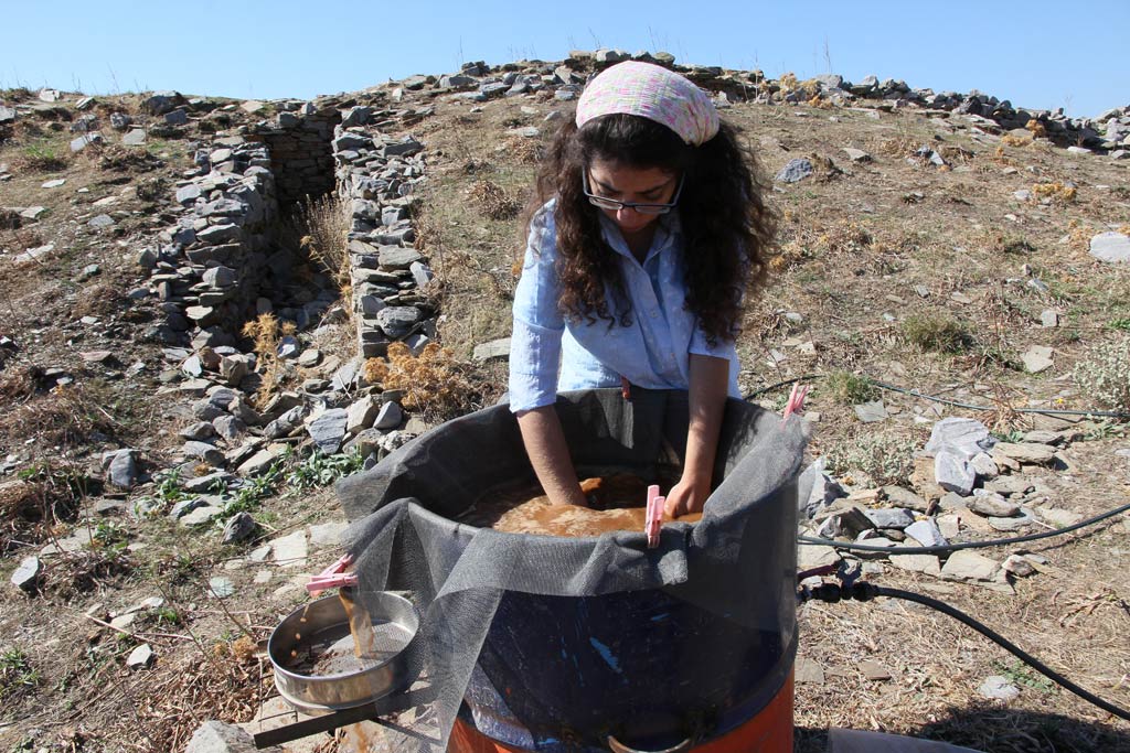 Roza washing the material in the water to remove soil from the stones, seeds, bones and other material