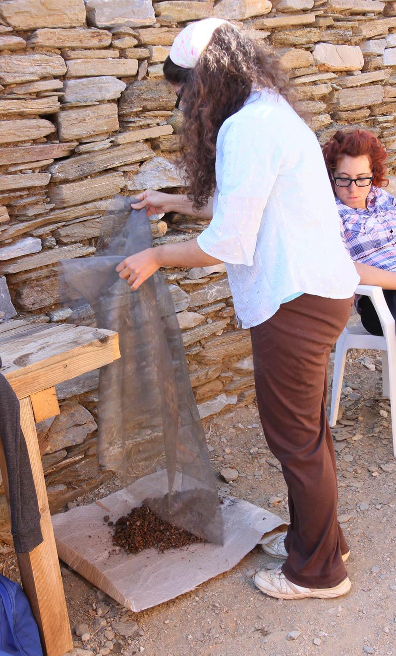 Roza places the washed debris on sheets on the ground to dry, in preparation for sorting