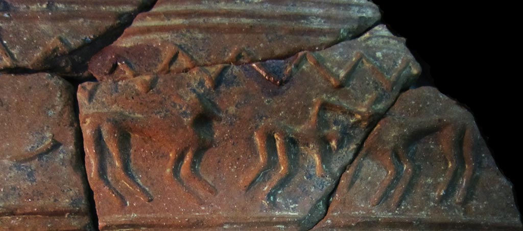 Ceramic sherds with applied relief showing a man attacking a lion, with another lion approaching him from behind