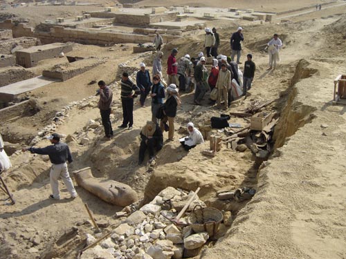 One of the Late Period (664-525 BCE) coffins in situ after clearing. In the distance you can see the mastaba (Arabic word for "bench") tombs belonging to high officials of the King