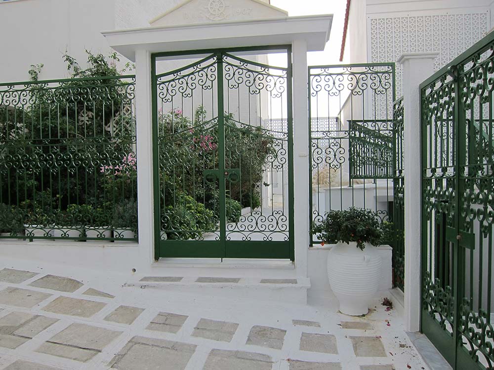 Green lace metalwork gate of a house at Chora