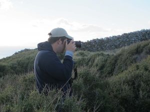 Hugh Thomas photographing from a bush