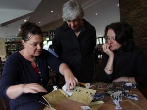 Kate Lamerton (left) shows Meg Miller (standing) and Lesley Beaumont how the house model is constructed