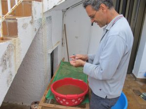 Stavros cleaning an artefact with a wet toothbrush