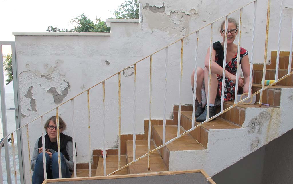 Jane McMahon and Beatrice McLoughlin cleaning artefacts on the steps at the back of Andros Museum