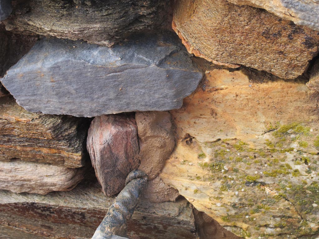 Stefie poking earth-based mortar between rocks