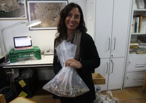 Melanie Fillios holding a bag of bones which she is about to sort